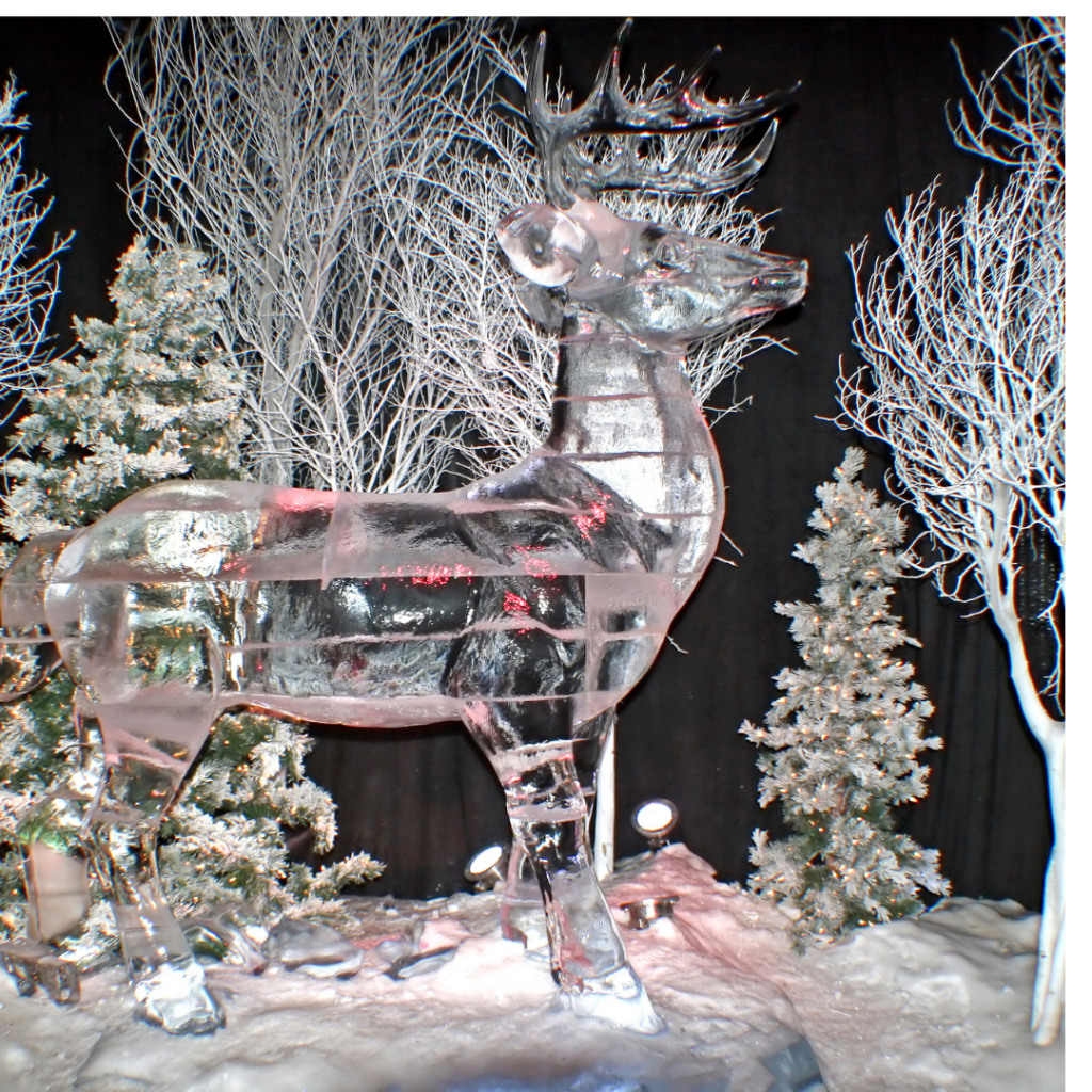 ice sculpture of a deer in an outdoor setting with evergreens and red ornaments
