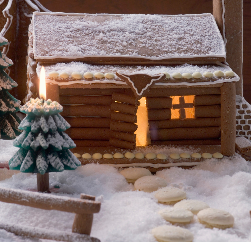 log cabin gingerbread house with white chocolate dots as stepping stone to front door and green tree made with candy